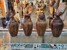 three wooden vases sitting next to each other in front of an egyptian display case