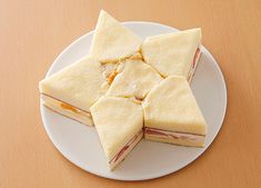 small sandwiches are arranged on a white plate