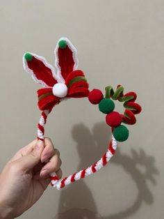 a hand holding a red and green christmas hat