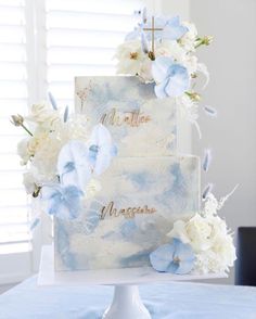 a wedding cake with blue and white flowers