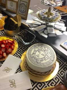 a table topped with cakes and fruit on top of plates