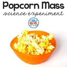 an orange bowl filled with popcorn on top of a white table next to the words pop corn mass science experiment