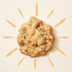 an oatmeal cookie sitting on top of a white surface with yellow rays