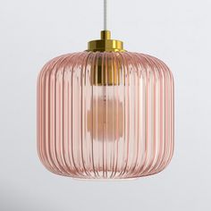 a pink glass pendant light hanging from a metal rod with a gold colored fittings