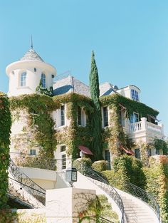 a large white building with ivy growing on it's side and stairs leading up to the top