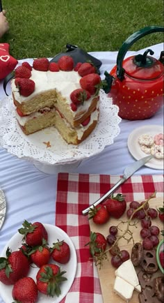 a table topped with cakes and desserts on top of a checkered table cloth