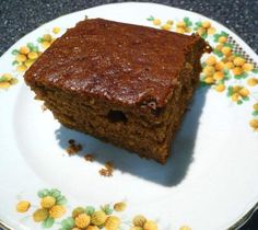 a piece of cake sitting on top of a white and yellow flowered saucer