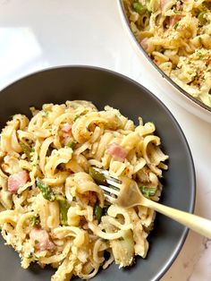 a plate of pasta with ham and broccoli on it next to a bowl of noodles