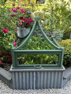 an outdoor garden with flowers and plants in the background, surrounded by metal planters