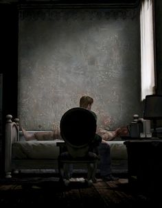 a man sitting on a bed in a dark room