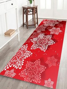 a red rug with snowflakes on it in a white room next to a table