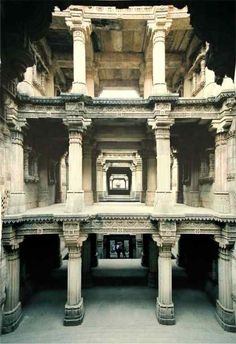 the inside of an old building with columns and pillars in it's center area