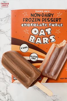 an ice cream bar with chocolate fudge and oat bars on the top, next to it's wrapper