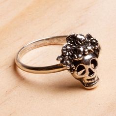 With flowers atop her skull Catrina is gorgeous. Oscar Figueroa Escorcia creates this excellent cocktail ring from gleaming Taxco sterling silver with oxidation enhancing the details. The skull tops a slender sterling band.The original La Calavera Catrina was a zinc etching created by the artist Jose Guadalupe Posada in Mexico around 1910. Posada created the character a female skeleton with an elegant hat as a satirical portrait of Mexican natives who aspired to European style and denied their o Catrina Costume Jewelry, Adjustable Stamped 925 Skull Ring As Gift, Adjustable 925 Stamped Skull Ring For Gift, Adjustable Silver Skull Ring Nickel Free, Adjustable Nickel-free Silver Skull Ring, Nickel-free Skull Jewelry For Day Of The Dead, Nickel Free Skull Jewelry For Day Of The Dead, Bohemian Sterling Silver Skull Jewelry, Catrina Costume