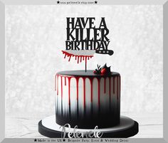 a black and white cake with red drips on it that says have a killer birthday