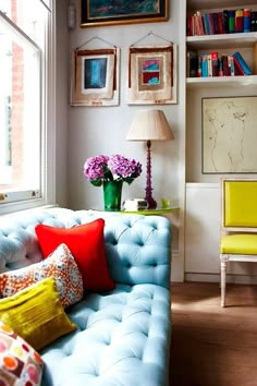 a living room filled with furniture and lots of books on the shelves next to a window