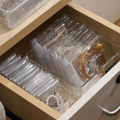 the drawers are filled with watches and bracelets in clear plastic containers on top of each other