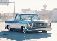 an old pickup truck parked in a parking lot