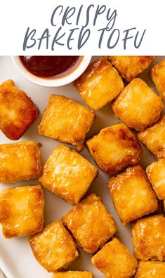 crispy baked tofu on a white plate with ketchup and dipping sauce