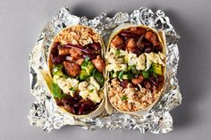 two burritos filled with meat, beans and veggies on tin foil