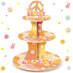 a three tiered cake stand with flowers and peace signs on it