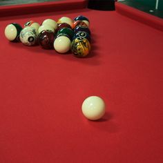 billiards balls and cues on a red pool table