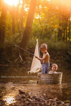 two young boys fishing in a small boat on the river at sunset with their dad