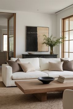 a living room filled with furniture and a large painting hanging on the wall above it