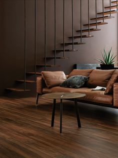 a living room filled with furniture and a spiral staircase in the backround behind it