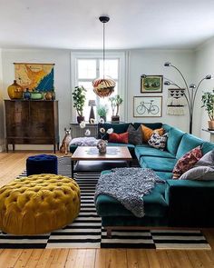 a living room filled with lots of furniture and decor on top of a hard wood floor