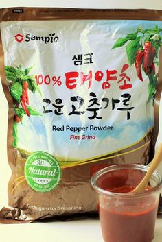 a bag of red pepper powder next to a cup of sauce