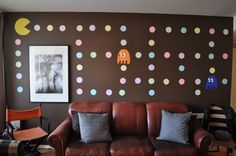 a brown leather couch sitting in front of a wall with polka dot decals on it