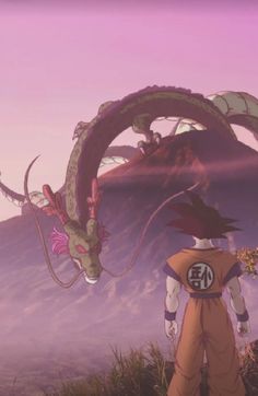 a man standing on top of a lush green hillside next to a dragon flying over him