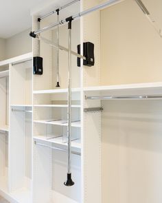 an empty walk in closet with white shelves