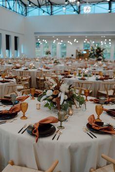 the tables are set with white linens and gold place settings for an elegant wedding reception