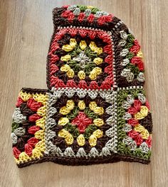 two crocheted potholders sitting on top of a wooden table