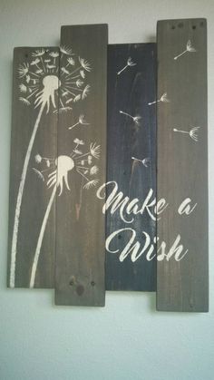 three wooden planks with painted dandelions and the words make a wish on them