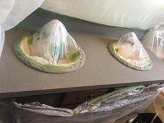 two plastic hats sitting on top of a counter next to a bag filled with something