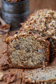 sliced loaf of banana nut bread on a wooden cutting board with walnuts around it