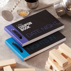 two books sitting on top of each other next to wooden blocks and measuring spoons