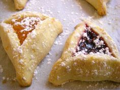 three pastries with powdered sugar on them are arranged in the shape of triangles