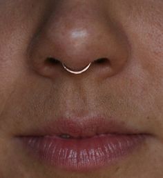 a woman's nose with a thin nose ring on it