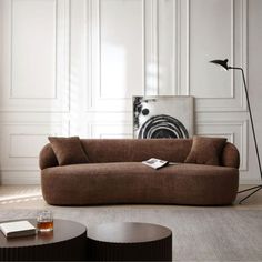 a living room filled with furniture and a lamp next to a wall mounted art piece