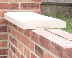 a close up of a brick wall with grass in the background