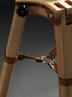 a wooden chair with leather straps attached to it