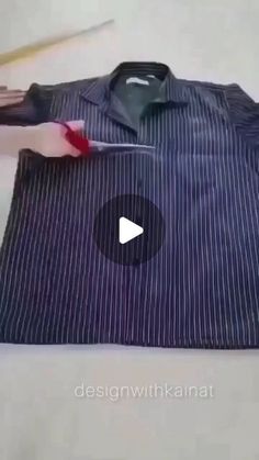 a shirt is being sewn on with scissors and sewing needles in the back ground