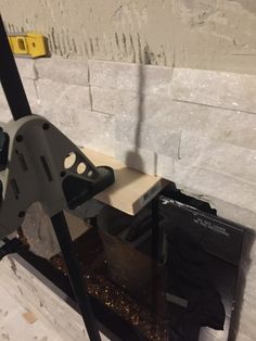 a piece of wood is being worked on with a circular sawtoothing machine in front of a white brick wall