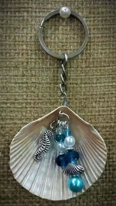 a seashell keychain with sea shells and pearls on it