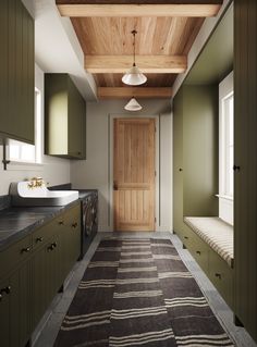 a long hallway with green cabinets and a rug on the floor in front of it