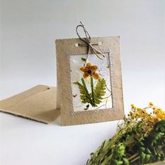 a card with some flowers on it next to a bunch of leaves and paper bags